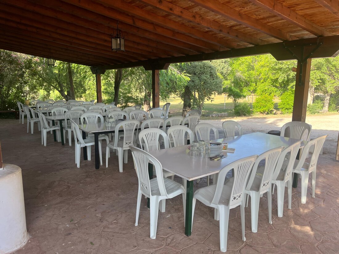 Porche cubierto de la finca, con mesas para comer al aire libre