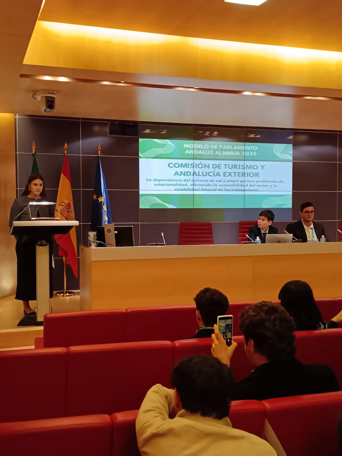 Alumna de ChezNous interviniendo en el atril durante la Comisión de Turismo y Andalucía Exterior