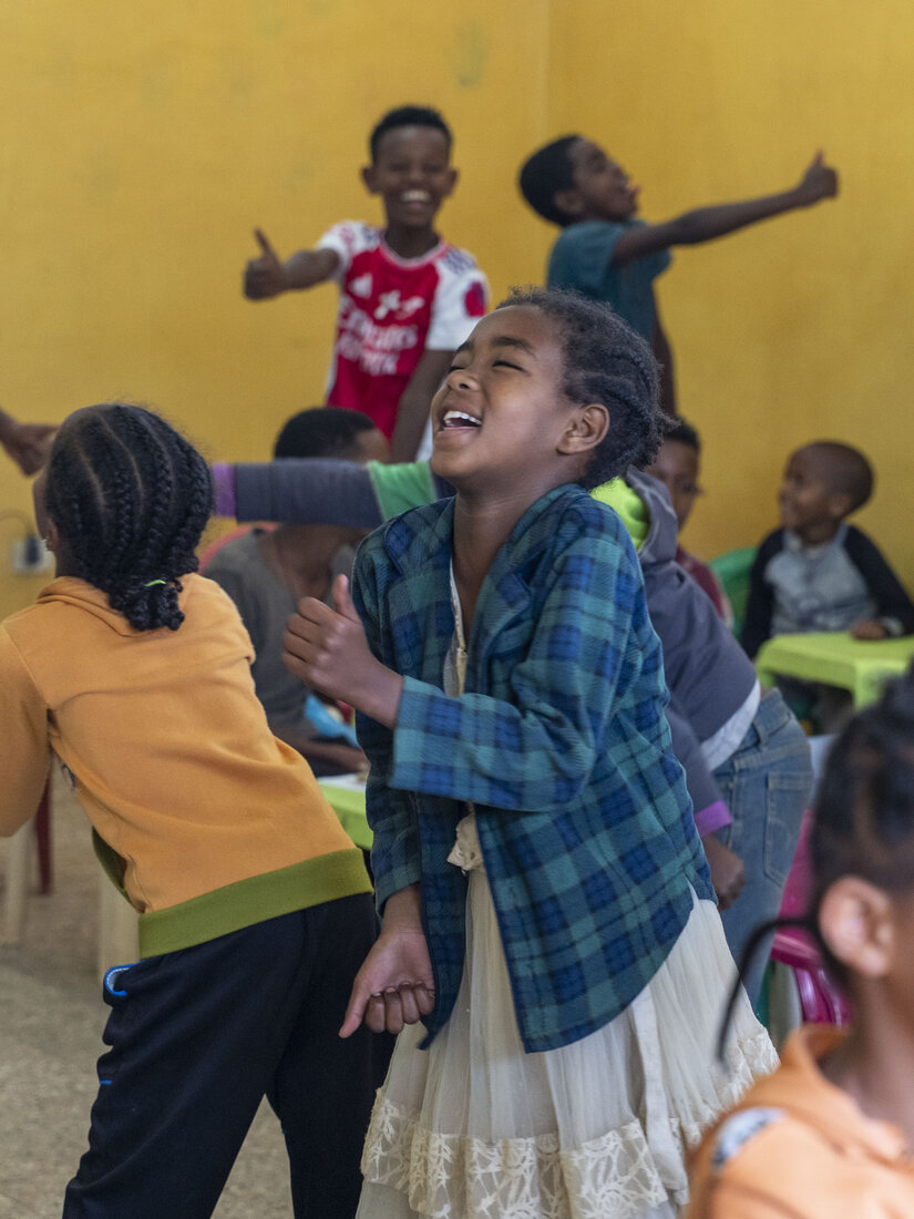 Niños riendo y jugando dentro del aula