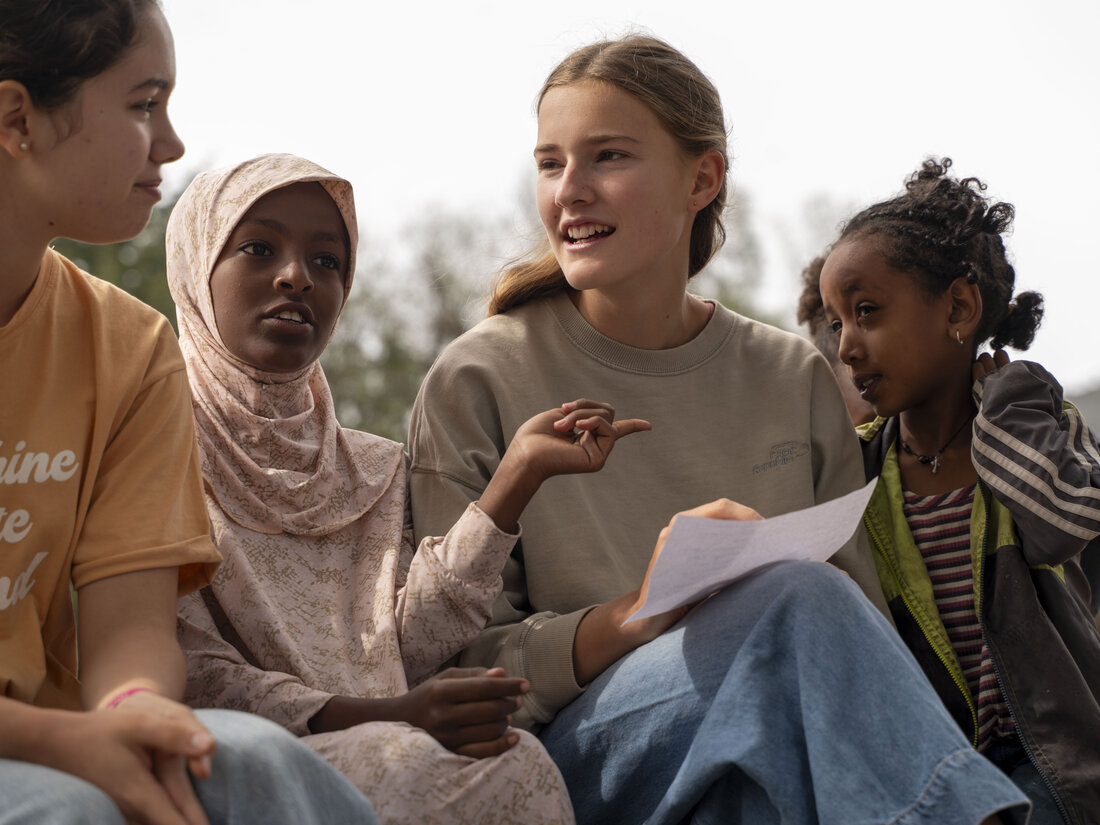 Alumnas de ChezNous conversando con niñas locales al aire libre